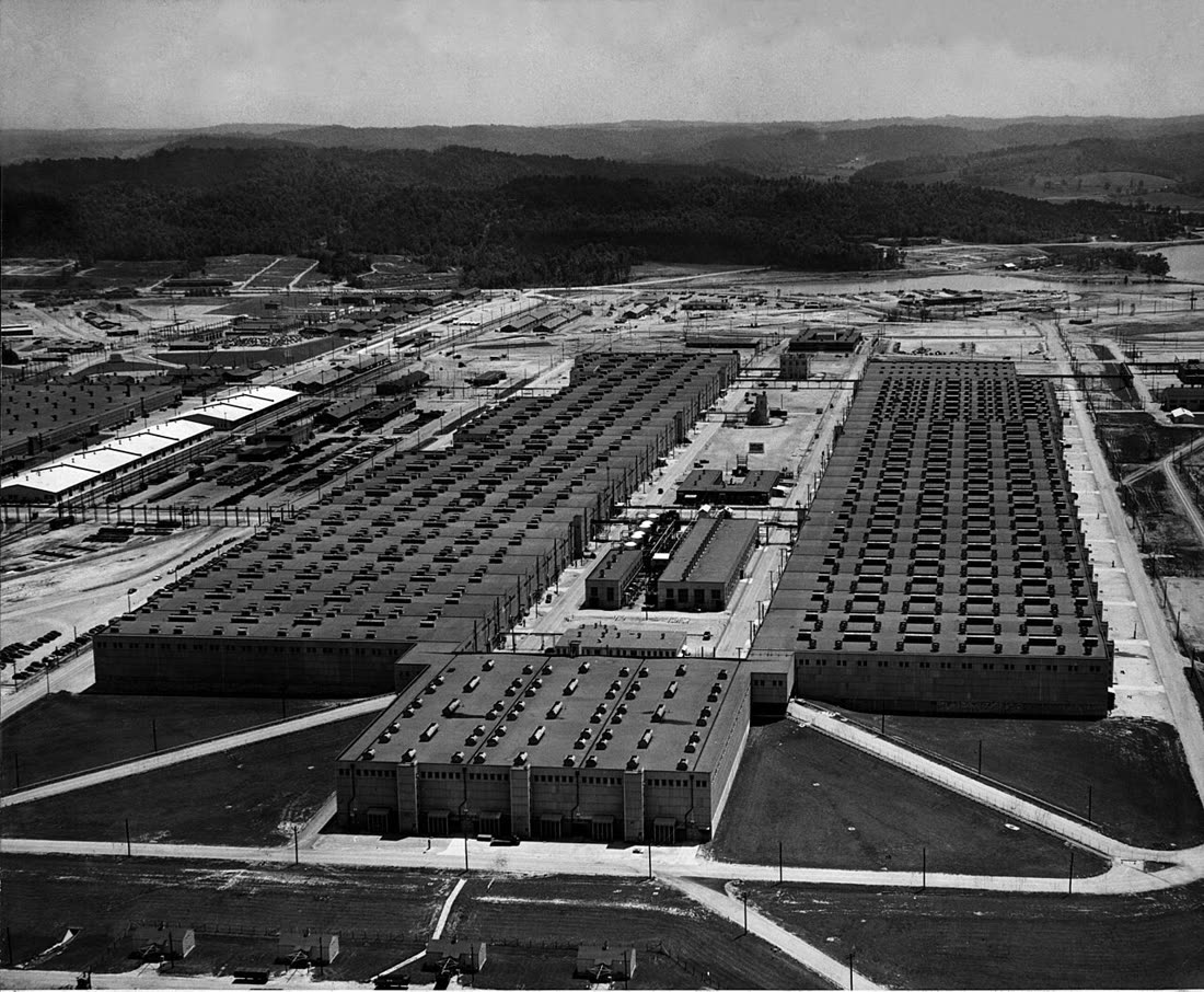 1947 年的 K-25 工厂航拍照片，两条极长的厂房在近处相连，呈 U 字形，屋顶上有一排排通风口