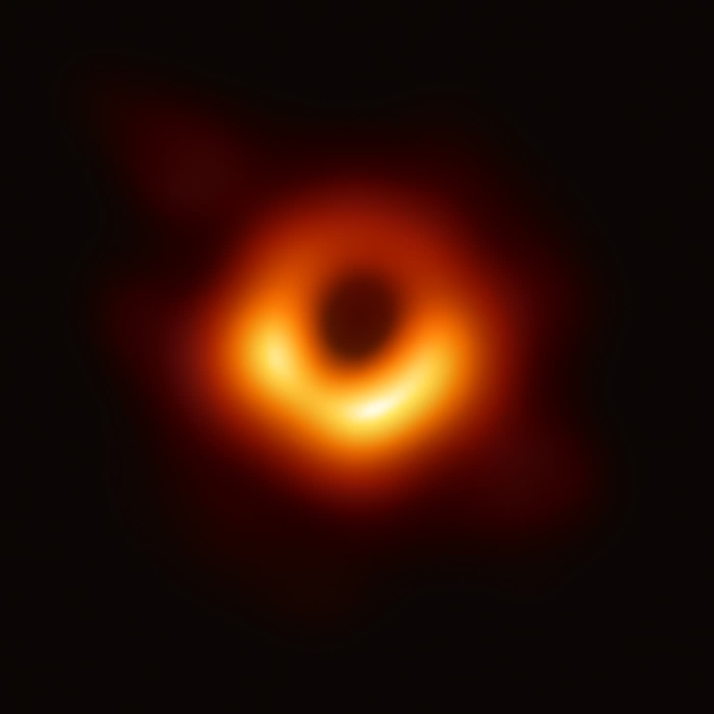 M87 星系中心黑洞的图像：黑色背景上一个橙色发光圆环，中心是暗区，环的下方更亮
